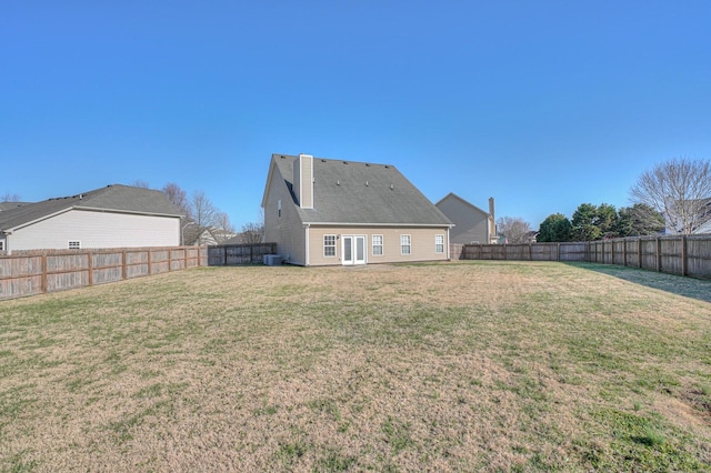 back of house featuring a fenced backyard and a lawn