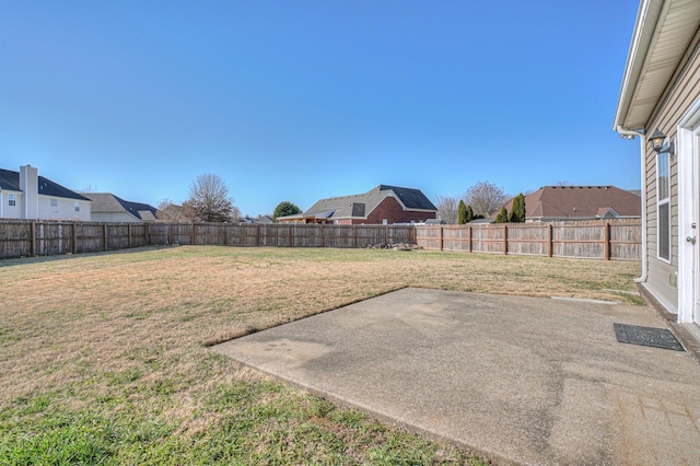 view of yard with a patio, a fenced backyard, and a residential view