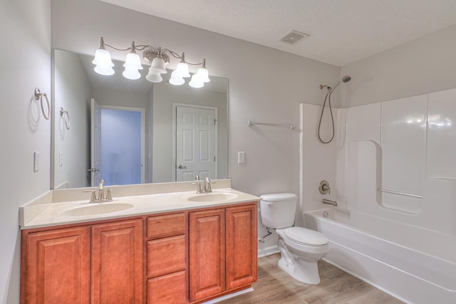 bathroom featuring visible vents, a sink, toilet, and wood finished floors