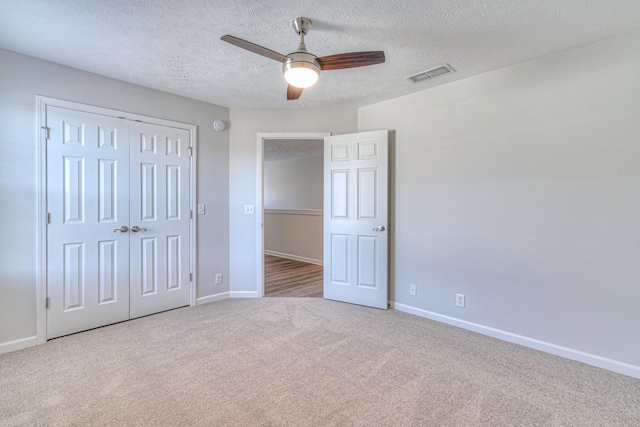 unfurnished bedroom with carpet floors, baseboards, visible vents, and a closet