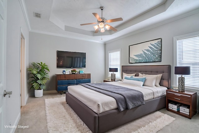 carpeted bedroom featuring a raised ceiling, visible vents, crown molding, and baseboards