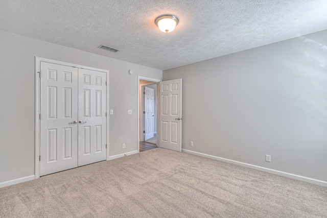 unfurnished bedroom featuring a closet, carpet, visible vents, and baseboards