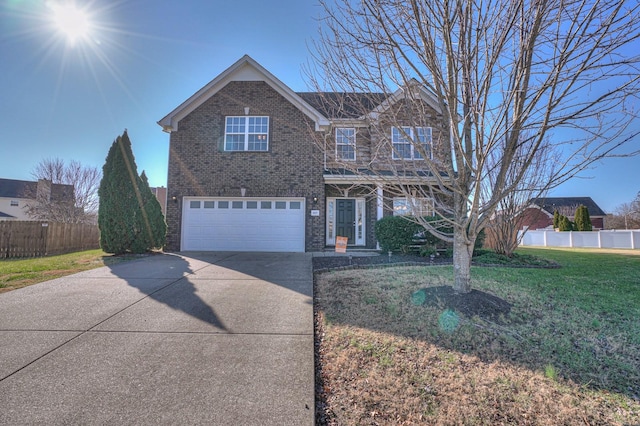 traditional-style home featuring a front yard, brick siding, driveway, and fence