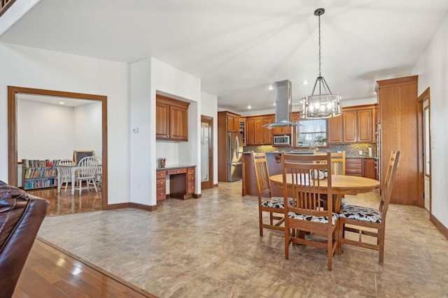 dining area featuring light wood-type flooring, baseboards, and built in desk