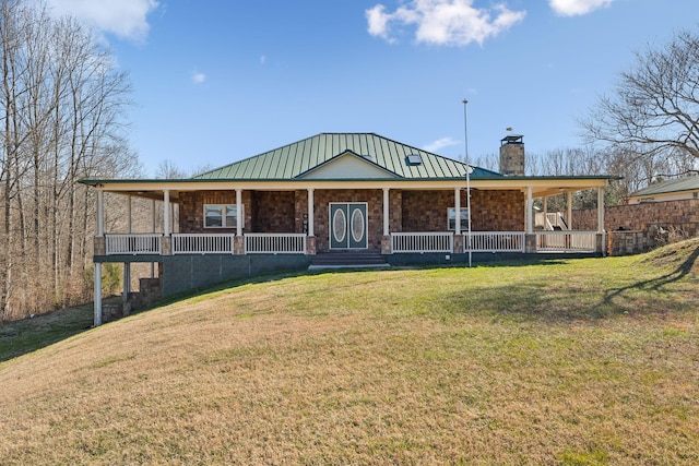 farmhouse inspired home with a standing seam roof, metal roof, covered porch, a chimney, and a front yard