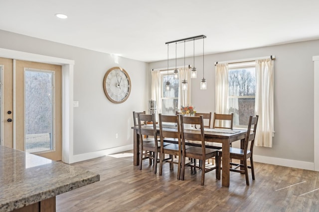 dining room with baseboards, wood finished floors, and recessed lighting