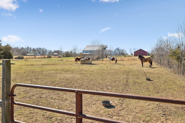 view of yard featuring a rural view, fence, and an outdoor structure