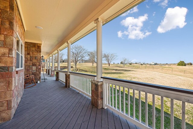 wooden terrace with a porch and a rural view