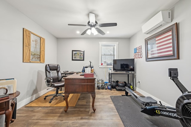 office space featuring recessed lighting, a wall mounted AC, a ceiling fan, wood finished floors, and baseboards