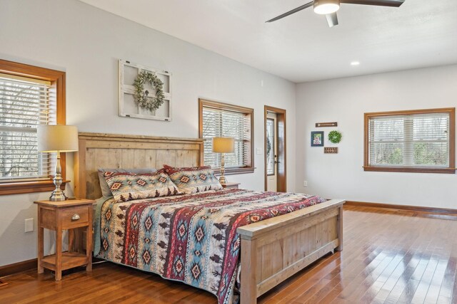 bedroom with a ceiling fan, multiple windows, baseboards, and hardwood / wood-style flooring