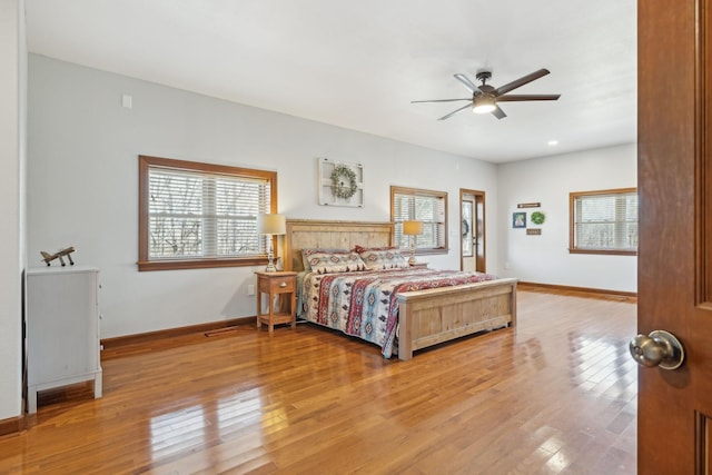 bedroom with light wood-type flooring, multiple windows, and baseboards