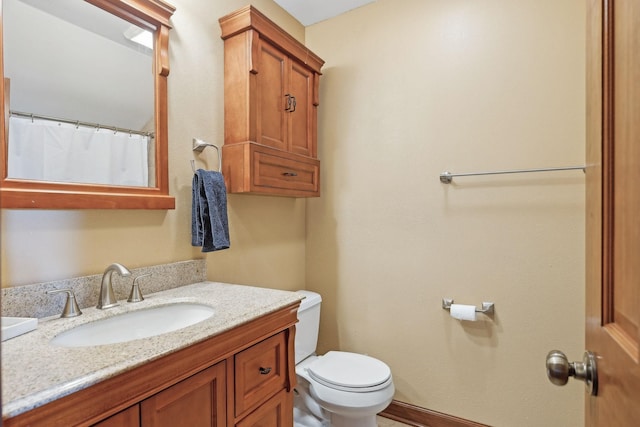 full bathroom with toilet, baseboards, and vanity