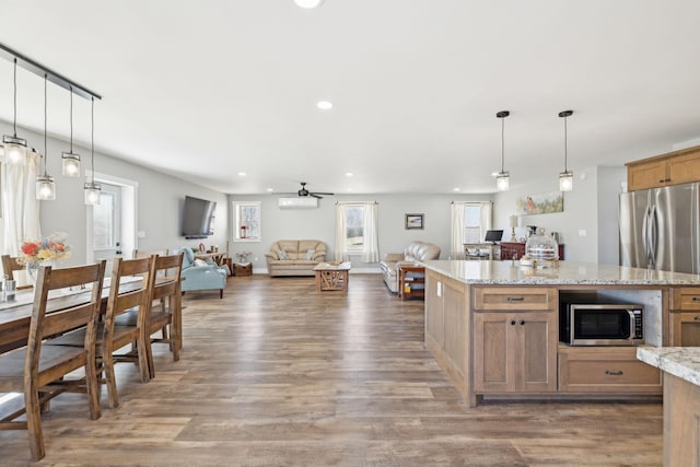 kitchen featuring appliances with stainless steel finishes, open floor plan, wood finished floors, and recessed lighting