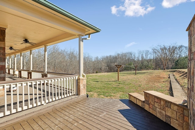 wooden terrace with ceiling fan and a yard