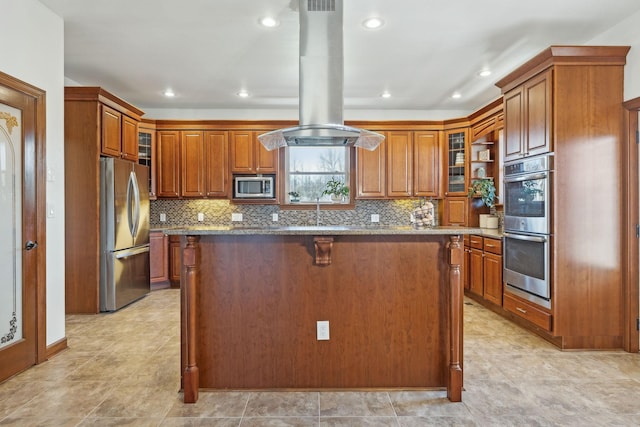 kitchen featuring brown cabinetry, island exhaust hood, light stone counters, and stainless steel appliances