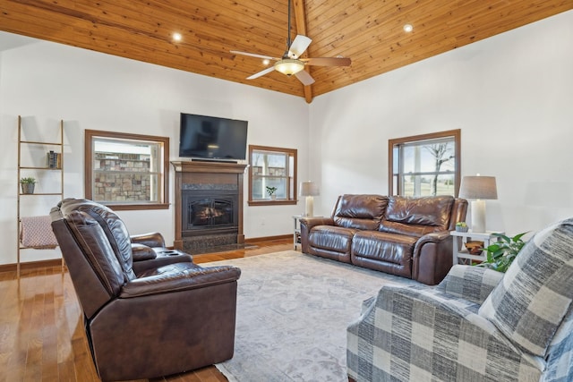 living area with a fireplace with flush hearth, wooden ceiling, plenty of natural light, and wood finished floors