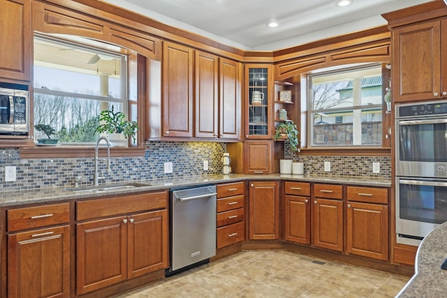 kitchen featuring appliances with stainless steel finishes, a sink, and brown cabinets