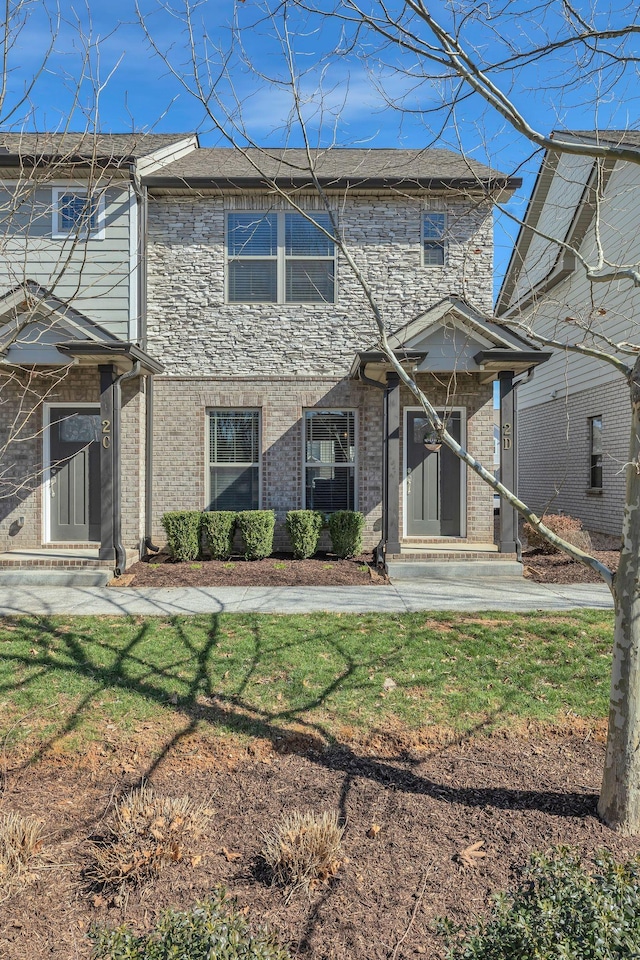 view of front of property featuring brick siding and a front yard