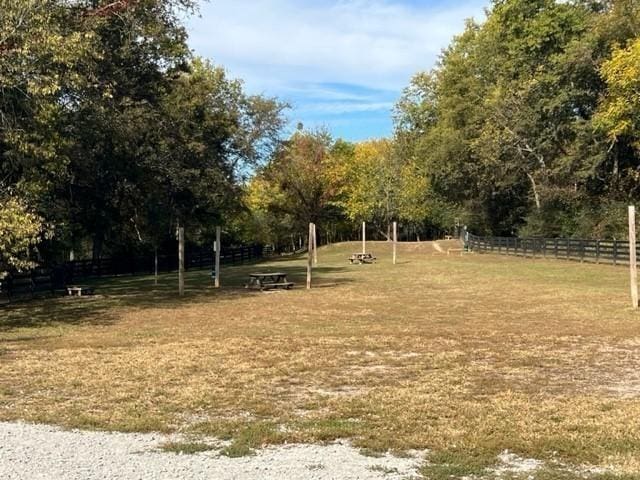 view of home's community with a lawn and fence