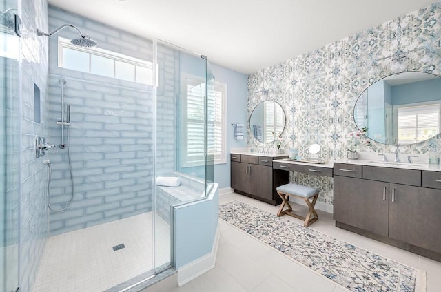 bathroom with tile patterned flooring, two vanities, a sink, baseboards, and a stall shower