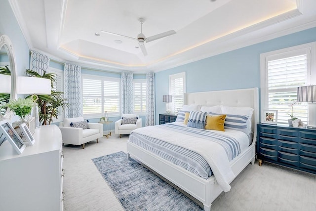 bedroom featuring a ceiling fan, a raised ceiling, carpet flooring, and crown molding