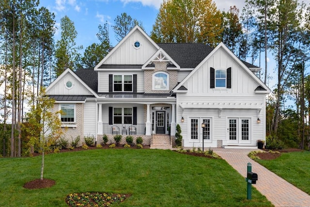 view of front of home with french doors, covered porch, board and batten siding, a standing seam roof, and a front lawn