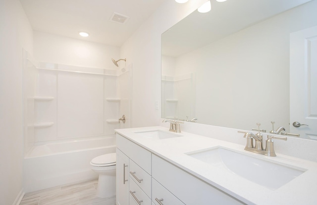 bathroom with visible vents, a sink, toilet, and double vanity