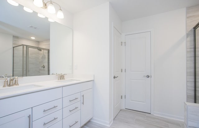 full bath featuring double vanity, a stall shower, visible vents, and a sink