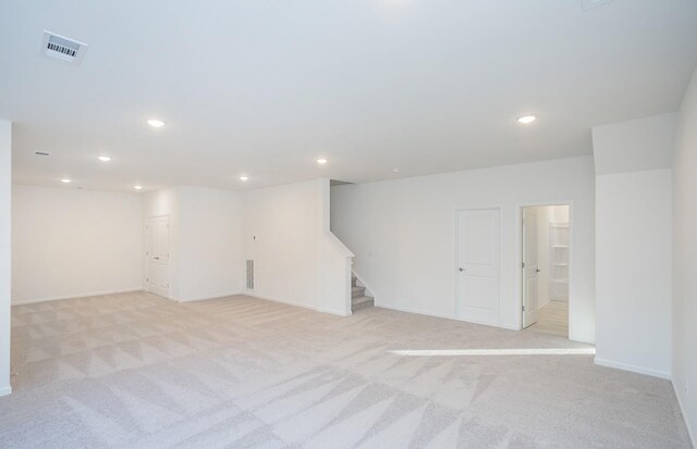 below grade area with stairs, light carpet, visible vents, and recessed lighting