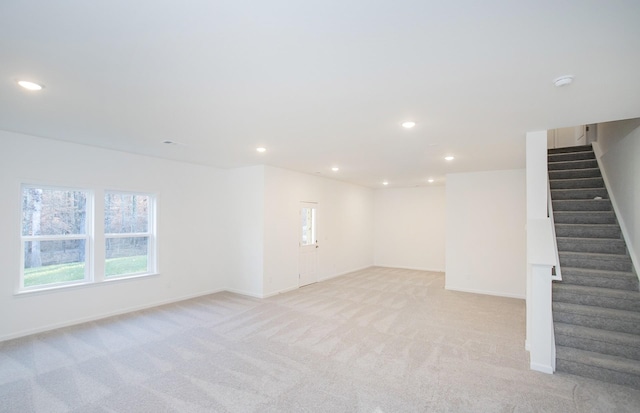 basement with light carpet, stairway, and recessed lighting