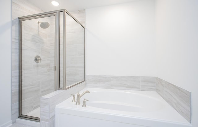 bathroom featuring a stall shower, a bath, and recessed lighting