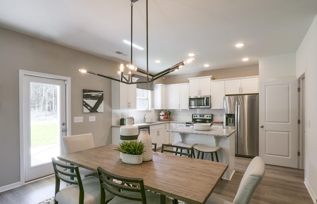 dining space featuring recessed lighting, visible vents, baseboards, and wood finished floors