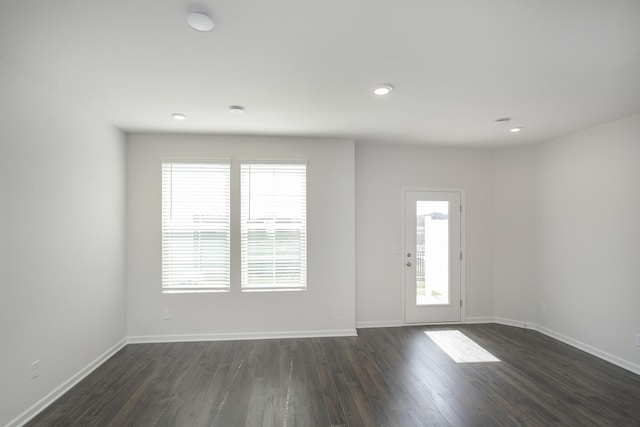 interior space with dark wood finished floors, plenty of natural light, baseboards, and recessed lighting