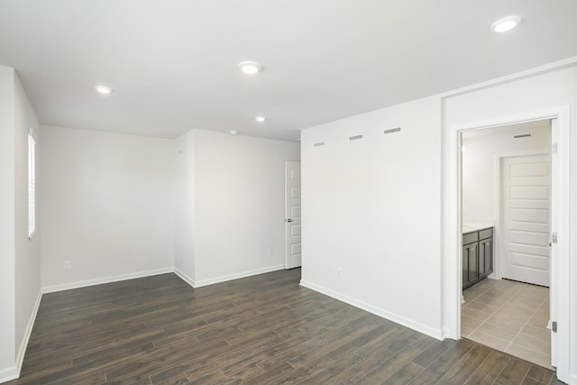 unfurnished room featuring dark wood-style floors, baseboards, and recessed lighting