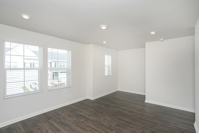 unfurnished room featuring baseboards, dark wood-type flooring, and recessed lighting