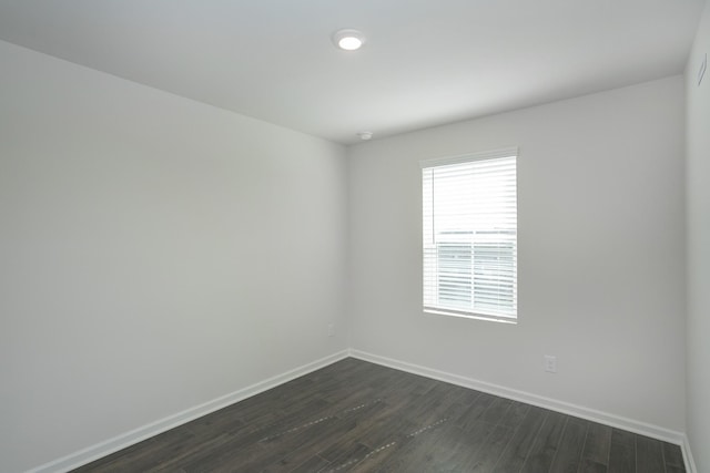 unfurnished room featuring dark wood-style floors and baseboards