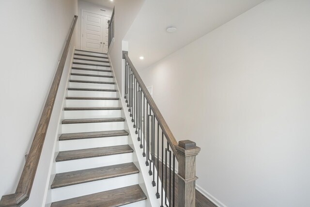 stairway featuring recessed lighting, baseboards, and wood finished floors