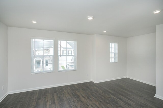 unfurnished room with dark wood-style flooring, recessed lighting, and baseboards