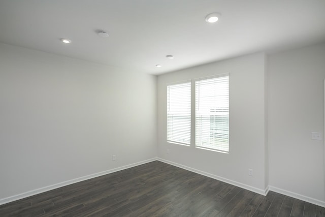 empty room featuring dark wood-style floors, recessed lighting, and baseboards