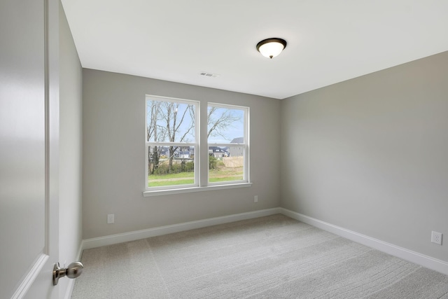 spare room featuring baseboards, visible vents, and carpet flooring