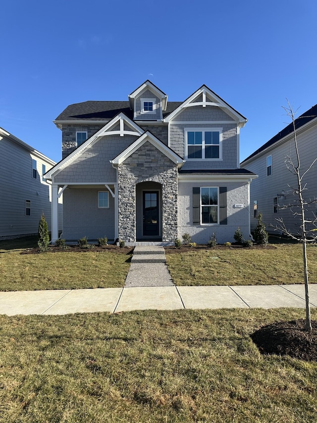 view of front of house with a front yard and stone siding