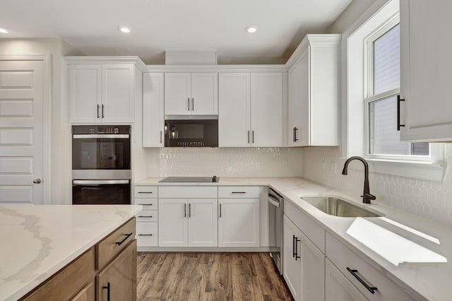 kitchen with white cabinetry, a healthy amount of sunlight, appliances with stainless steel finishes, and a sink