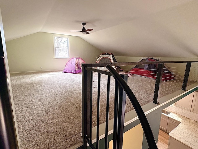 additional living space featuring vaulted ceiling, a ceiling fan, and light colored carpet