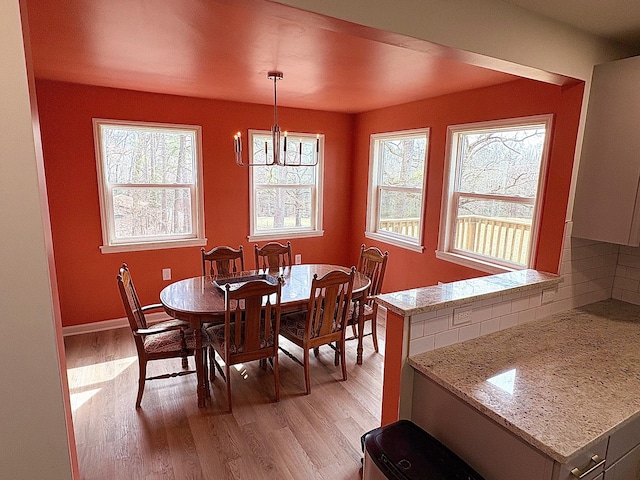 dining area with plenty of natural light, light wood-style flooring, and baseboards