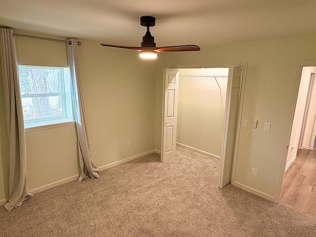 unfurnished bedroom featuring a closet, light colored carpet, and baseboards