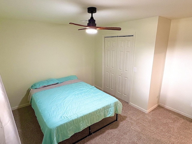 carpeted bedroom with a ceiling fan, a closet, and baseboards