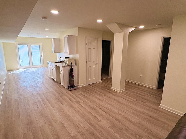 interior space with light countertops, light wood finished floors, and recessed lighting