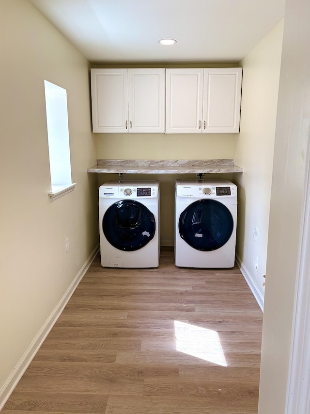 washroom with light wood-type flooring, baseboards, and washer and dryer