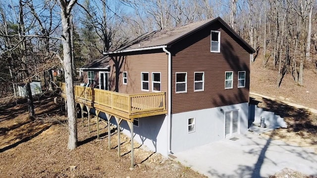 view of side of home with a wooden deck and a patio