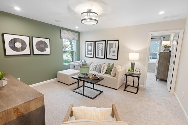 living area with recessed lighting, light colored carpet, visible vents, and baseboards